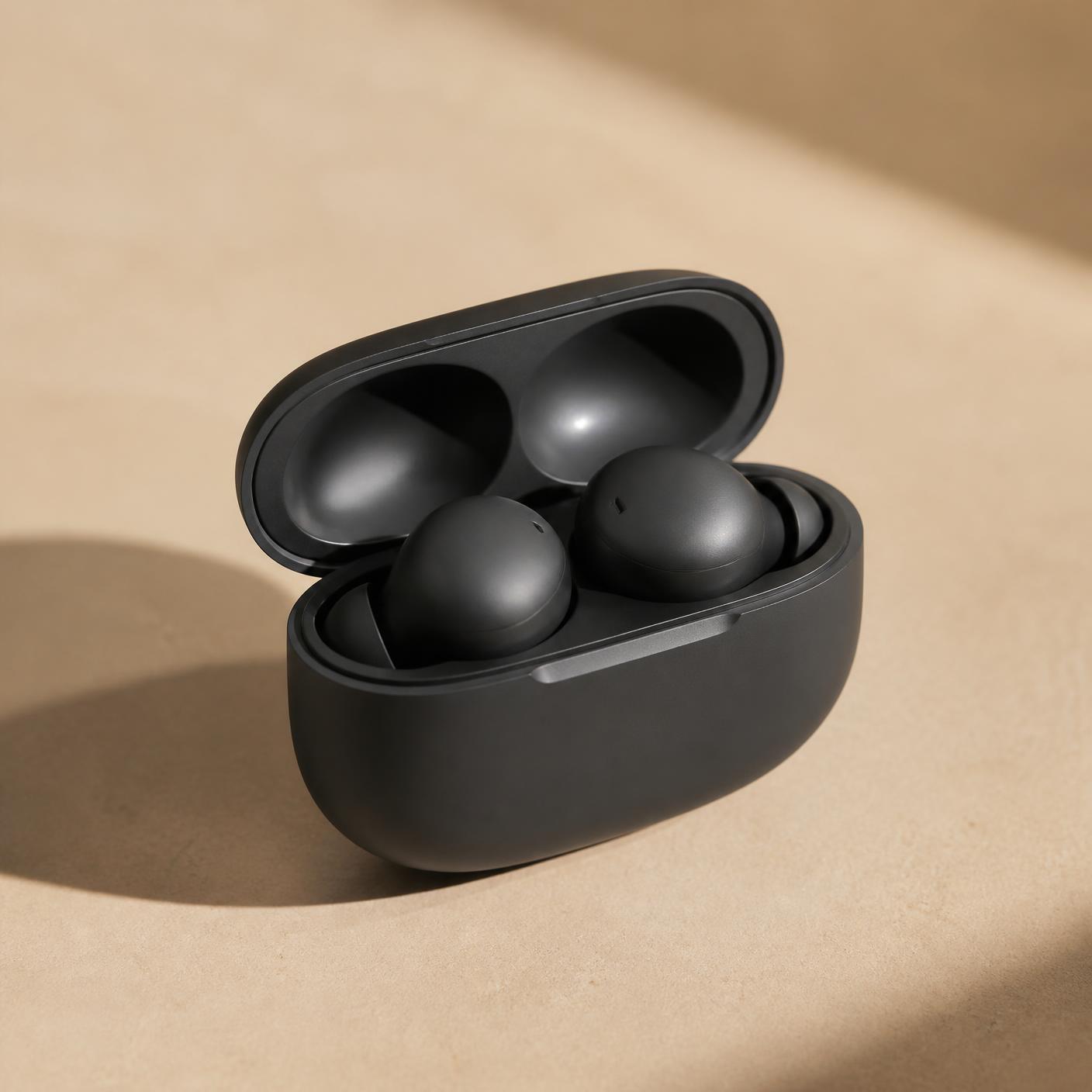 Graphite Studio ANC Earbuds resting in their open charging case